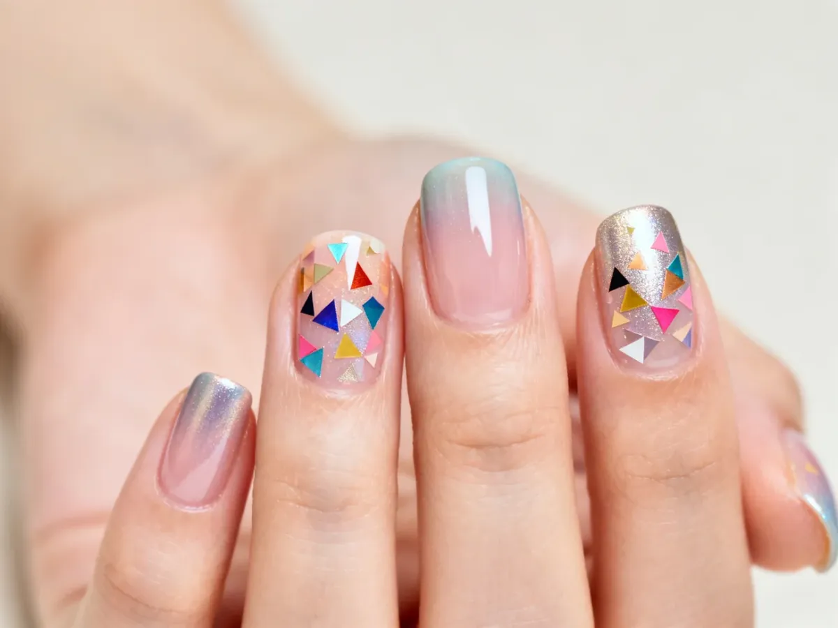 Manicure z kolorowymi ozdobami kamifubuki zatopionymi pod błyszczącym topem