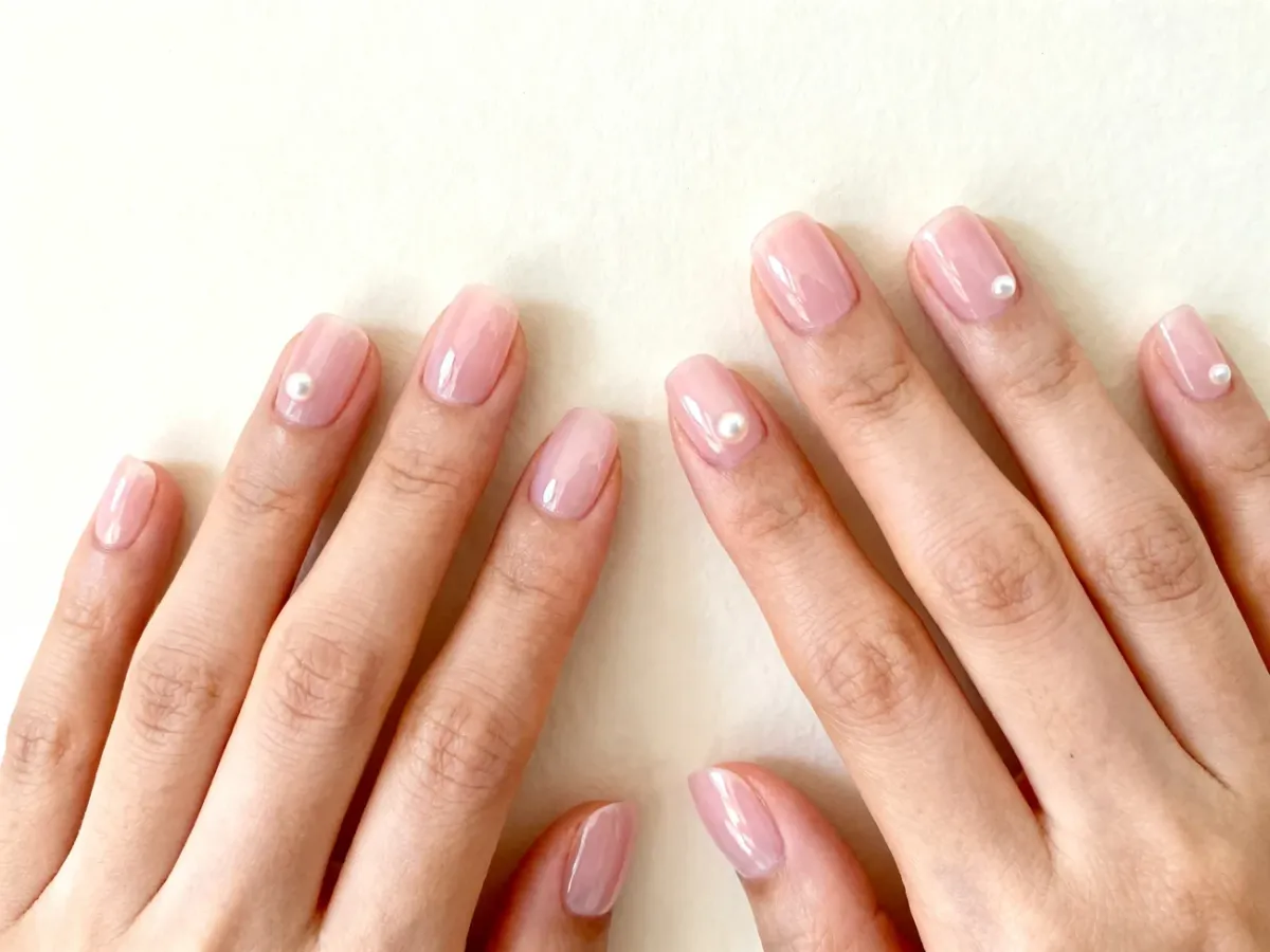 Krótkie paznokcie w mlecznoróżowym, półtransparentnym manicure z delikatnym połyskiem