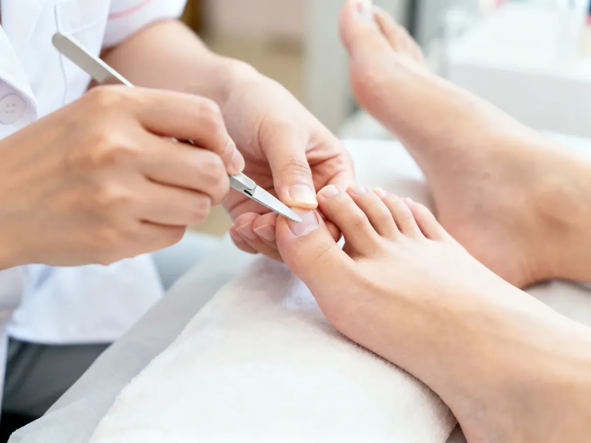 Kosmetyczka wykonująca klasyczny pedicure w higienicznym salonie